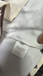 Macro view of the care label on a printed satin skirt showing material composition