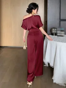 Back view of an elegant wine red satin wide-leg jumpsuit featuring a one-shoulder design.