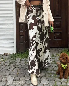 Fashionable satin midi skirt with brown cow print pattern shown in an outdoor setting