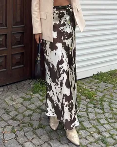 Detail shot of cow print satin maxi skirt with high waist and thin belt styling
