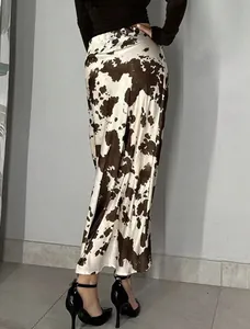 Detailed back view of a slim-fit satin long skirt with brown and white cow print