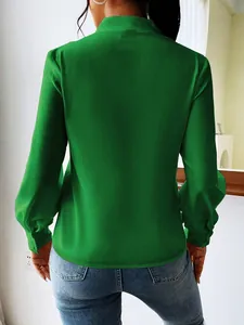Back view of a vibrant green satin blouse showing smooth fabric texture and loose fit