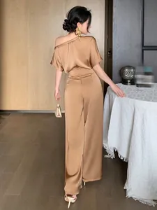 Back view of elegant satin jumpsuit with asymmetrical shoulder design in bronze