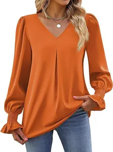 Detail view of women's orange satin V-neck blouse with lantern sleeves on model
