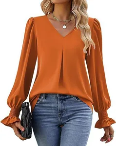 Detailed view of an orange satin V-neck blouse with flared ruffled cuffs.