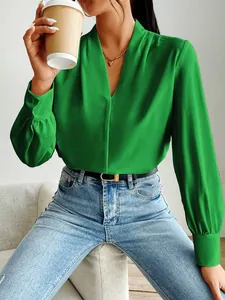 Close-up of a model wearing a green satin V-neck blouse with elegant pleated cuffs