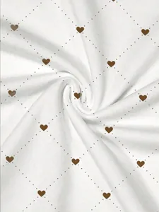 Close-up of white t-shirt fabric featuring brown heart and dotted diamond pattern