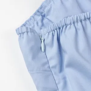 Detailed view of the invisible side zipper and elastic waistband on a light blue bandeau top