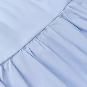 Close-up of light blue pleated fabric detail on a fashionable women's tube top dress.