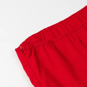 Detail of the elastic band and side zipper on a vibrant red strapless tube top