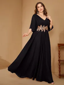 Elegant plus size black V-neck evening dress with gold floral embroidery and ruffle sleeves.