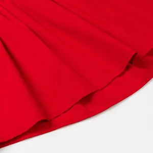 Close-up detail of the fine stitching on the hem of a red strapless top