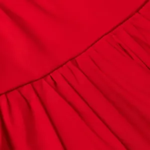 Detailed macro shot of gathered pleats on a vibrant red fashion garment fabric texture.