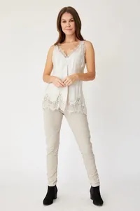 White silk camisole with delicate lace trim on neckline and hem, worn by a female model.