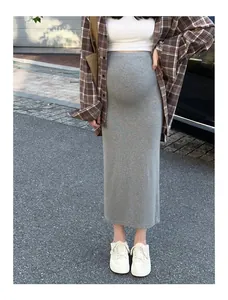 Jupe de maternité grise en tricot portée avec chemise à carreaux et baskets