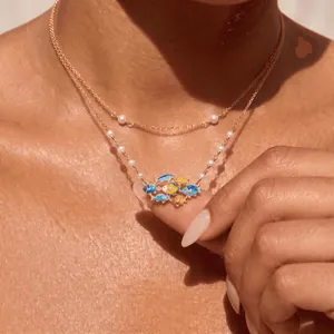 Dettaglio di una collana di perle a doppio strato con ciondoli a forma di pesci