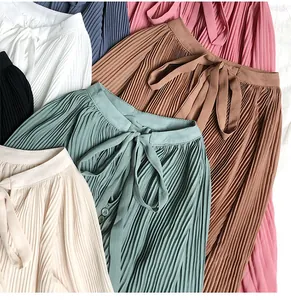 Close-up detail of pleated chiffon blouses featuring various elegant colors and tie-neck