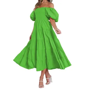 Détail d'une robe midi à volants vert vif, épaules dénudées, manches bouffantes et bustier.