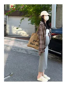 Jupe midi de maternité en tricot gris portée par un mannequin enceinte en extérieur