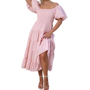 Vue de la robe rose à épaules dénudées avec buste smocké, volants étagés et manches bouffantes.
