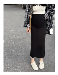 Détail d'une jupe longue de maternité en tricot noir de coupe droite sur un mannequin