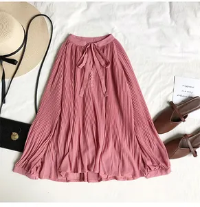 Elegant detail of pink pleated chiffon blouse featuring a tie-neck and retro V-neck.