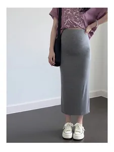 Gros plan d'une jupe midi de grossesse en tricot gris moulante pour l'automne.