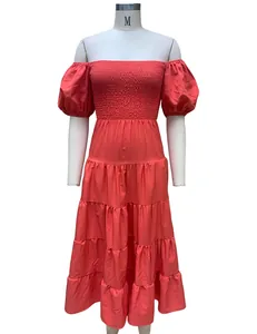 Vue de face de la robe mi-longue corail à épaules dénudées avec buste smocké et volants