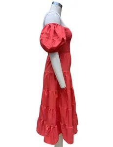 Vue latérale d'une robe midi corail à épaules dénudées et manches bouffantes.