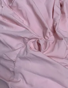 Gros plan sur la texture du tissu rose doux d'une robe d'été à manches bouffantes plissée