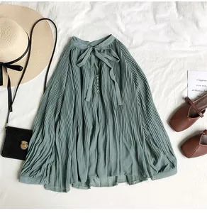 Detail of sage green pleated chiffon blouse with V-neck bow tie and buttons