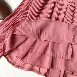 Close-up detail of a elegant pink pleated chiffon shirt showing fine fabric texture and stitching