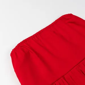 Close-up detail of the elastic band and pleated fabric texture on a vibrant red tube top