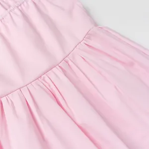 Macro detail showing the soft pleated fabric and fine stitching on a pink tube top