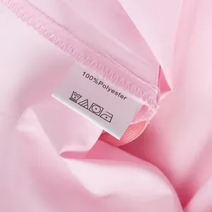 Close-up detail of the pink fabric and care label showing 100% polyester material.