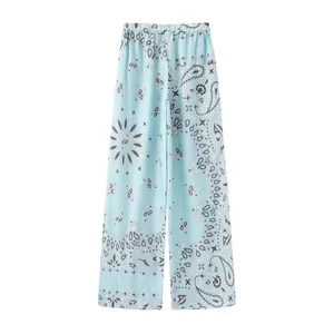 Detail of light blue wide-leg trousers featuring an intricate dark paisley print