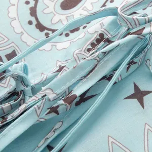 Detailed close-up of the intricate paisley and star print on light blue summer fabric