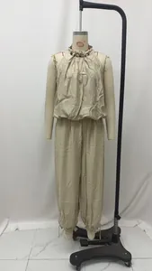 Dettaglio ravvicinato del set beige con top all'americana con perline e pantaloni