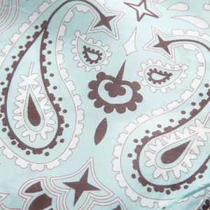 Close-up of light blue fabric featuring a dark brown and white paisley print pattern