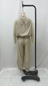 Vista posteriore di un set top senza maniche leggero e pantaloni a lanterna beige