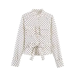 Elegant white long sleeve blouse featuring black polka dots and a waist tie belt