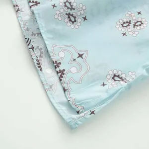 Close-up of the stitching and paisley print on the light blue summer set.
