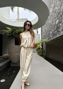 Modella indossa un set beige con top all'americana e pantaloni a palloncino, all'aperto
