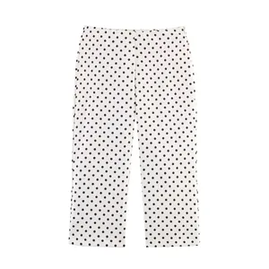 Detailed view of women's high-waist white pants with black polka dots