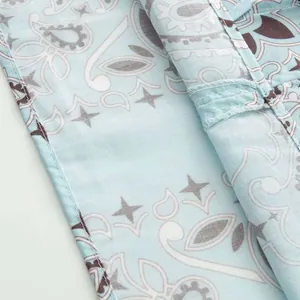 Macro view of light blue paisley print fabric showing high-quality stitching and hem details