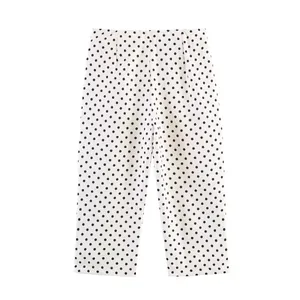 Detail view of white high-waisted pants with black polka dot pattern