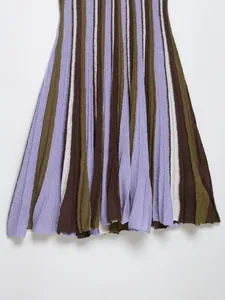 Close-up detail of a multi-colored striped knit dress with vertical texture and pleated hem