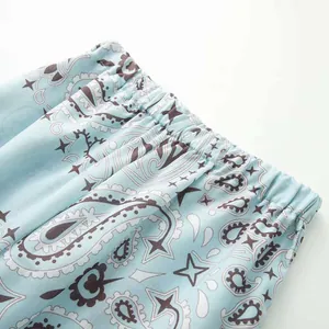 Detail shot of light blue paisley print clothing showing elastic waistband texture