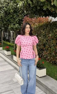 Detailansicht eines stylischen rosa gepunkteten Schößchen-Tops mit Puffärmeln