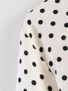 Close-up detail of white and black polka dot fabric with precise stitching
